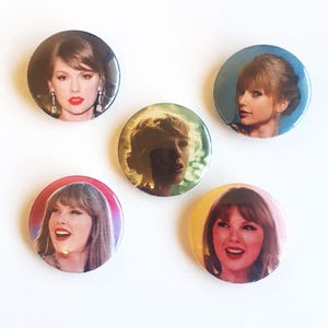 May include: Five round pinback buttons featuring different images of a woman with light skin and brown hair. The buttons have a glossy finish and are set against a white background. The woman is smiling in some of the images.