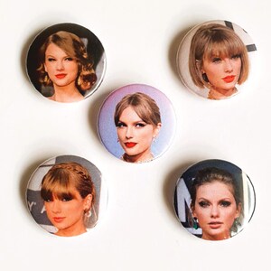 May include: Five round button pins featuring different images of a woman with blonde hair. The buttons are white with a silver border.