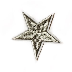 Op de afbeelding: Een zilveren stervormige strijkpleister, ongeveer ter grootte van een Nederlandse 1-cent munt.