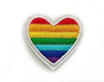 May include: Rainbow heart-shaped embroidered patch with a white outline. The patch is approximately 2 cm wide.
