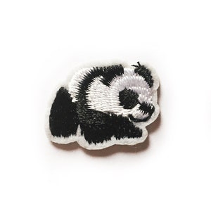 May include: A small, white embroidered panda bear patch. The patch is about the size of a US penny.