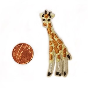 May include: A small embroidered iron-on patch of a giraffe with a brown and white pattern. The patch is about the size of a US penny.