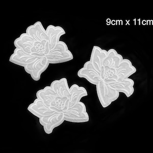 Puede incluir: Tres parches bordados de flores blancas, cada uno mide 9 cm por 11 cm.