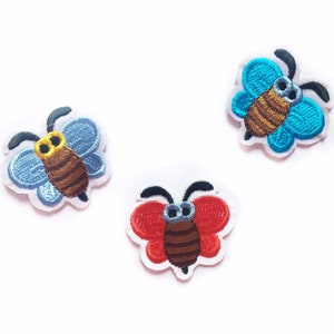 May include: Three embroidered iron-on patches featuring cartoon bees with blue, red, and turquoise wings.