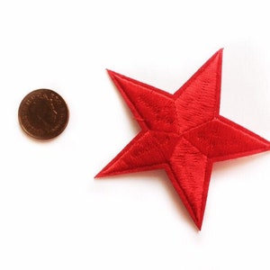 Puede incluir: Un parche de estrella roja de fieltro, aproximadamente del tamaño de una moneda de un céntimo de euro.