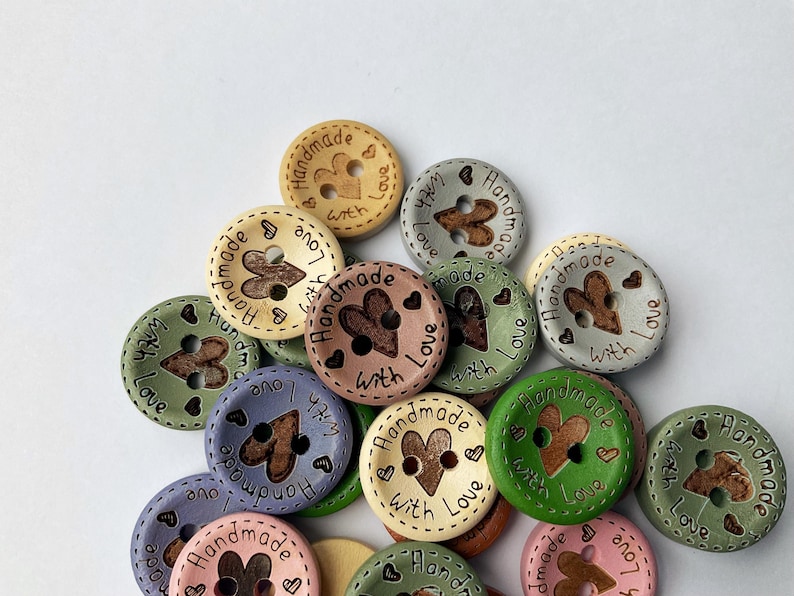 Mixed selection of pastel and earthy tone buttons for sewing baby cardigans.