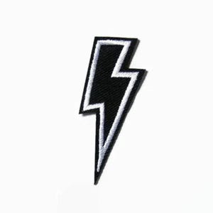 May include: Black and white lightning bolt iron-on patch. The patch has a white outline and a black interior.