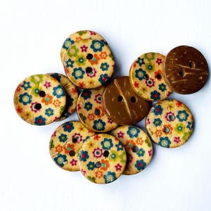May include: A collection of colorful wooden buttons with a floral pattern. The buttons are round and have two holes. Some of the buttons are brown and have a natural wood finish.