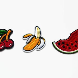 Può includere: Tre toppe ricamate da stirare che raffigurano una ciliegia rossa, una banana gialla e una fetta di anguria rossa.