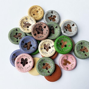 Close up of rustic wood buttons showing heart cut-out and engraved message.