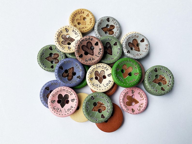 Close up of rustic wood buttons showing heart cut-out and engraved message.