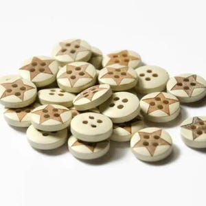 May include: A pile of wooden buttons with a star design. The buttons are beige with brown stars.