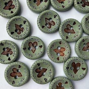 Heart cut-out wooden buttons to embellish scarves and hats. beautiful pastel sage green wooden buttons. 15mm in size with 2 holes