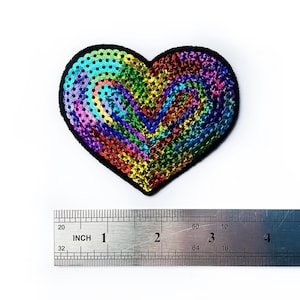 May include: A rainbow sequined heart-shaped patch, approximately 2 inches wide, with a black felt backing.