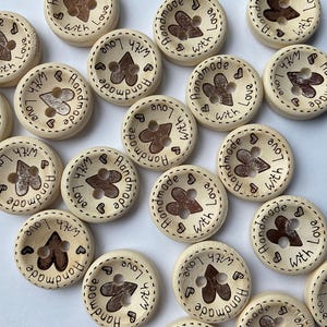 Close view of wood grain texture on 'Hand Made with Love' craft buttons.