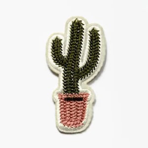 Puede incluir: Una planta de cactus verde en una maceta rosa, bordada en un parche de tela blanca.