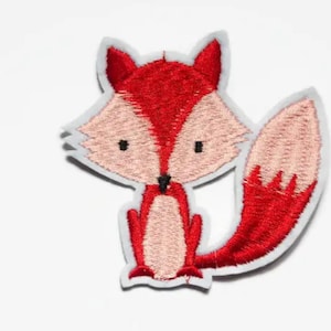 May include: Red and pink embroidered fox patch. The fox is sitting with its tail curled behind it.