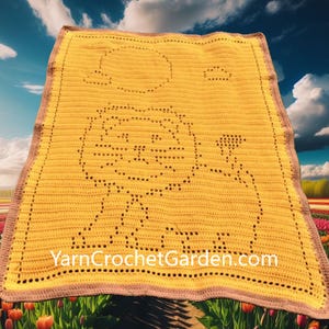 May include: A yellow crocheted blanket featuring a lion design with a sun and cloud. The blanket has a brown border and the text "YarnCrochetGarden.com" is visible. The blanket is displayed outdoors with a sky and flower field background.