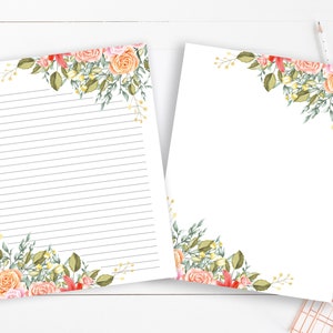 Peut inclure: Deux feuilles de papeterie blanche avec des motifs floraux d'angle. L'une est lignée, l'autre est vierge. Le motif floral présente des roses pêche et roses, des feuilles vertes et des accents jaunes. Un crayon repose sur la surface en bois blanc.