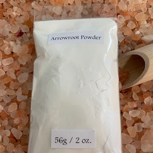 May include: A white plastic bag filled with white arrowroot powder. The bag has a label that reads "Arrowroot Powder" and "56g / 2 oz."