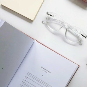 May include: Open book with a white background. The book is open to a page titled "Das erste Trimester" with text about the first trimester of pregnancy. The text is in German.