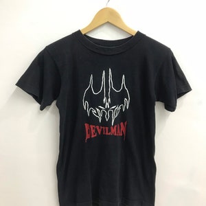 May include: Black t-shirt with a white graphic of a demon with the text "DEVILMAN" in red.