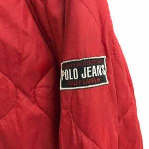 May include: Red quilted jacket with a black and white patch that reads "MANUFACTURED BY POLO JEANS RALPH LAUREN".
