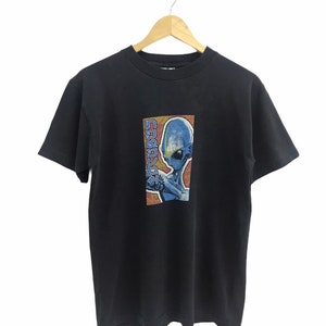 May include: Black t-shirt with a graphic print of a blue alien with the text "SUBWAY" in Japanese characters.
