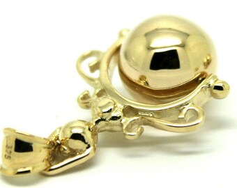 May include: A gold pendant featuring a round, spinning ball suspended within a decorative frame. The pendant has a bail for attaching to a chain.