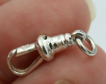 May include: Silver watch chain fob with a decorative, detailed design. The fob has a loop on one end and a hook on the other.