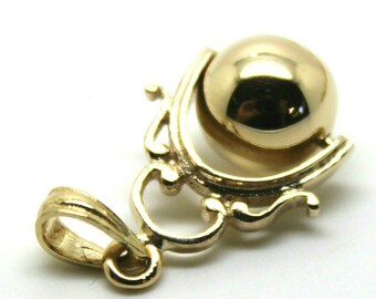 May include: A gold-colored pendant featuring a polished sphere cradled within an ornate, swirling design. The pendant has a loop for a chain and is set against a white background. The jewelry piece has a reflective surface.