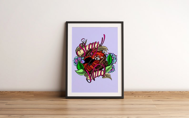 May include: A framed print with a purple background featuring a red panda curled up in a nest of leaves and flowers. The text "Stay Wild" is written in pink and white lettering.