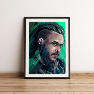 May include: Framed portrait of a man with a beard and green eyes. The artwork features a dark color palette with shades of green and black. The man's hair is styled in a modern undercut. The portrait is displayed on a white wall.