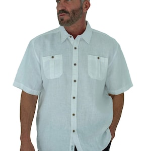 Puede incluir: Camisa de lino blanca de manga corta con botones y dos bolsillos de solapa con botones marrones.