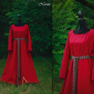 May include: A long, red dress with long sleeves and a belt. The dress is made of a soft, flowing fabric and has a simple, elegant design.