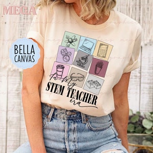 May include: A cream-coloured t-shirt featuring a STEM-themed graphic. The graphic includes science and maths icons like a microscope and calculator. The text "In My STEM Teacher Era" is printed below the icons. The shirt is made of Bella Canvas material.