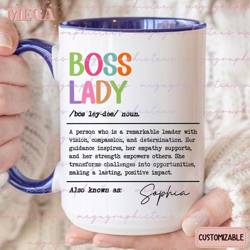 May include: White ceramic mug with a blue rim and handle. The mug has the words "Boss Lady" in colorful letters and a definition of the term. The definition reads: "A person who is a remarkable leader with vision, compassion, and determination. Her guidance inspires, her empathy supports, and her strength empowers others. She transforms challenges into opportunities, making a lasting, positive impact." The mug also says "Also known as: Sophia".