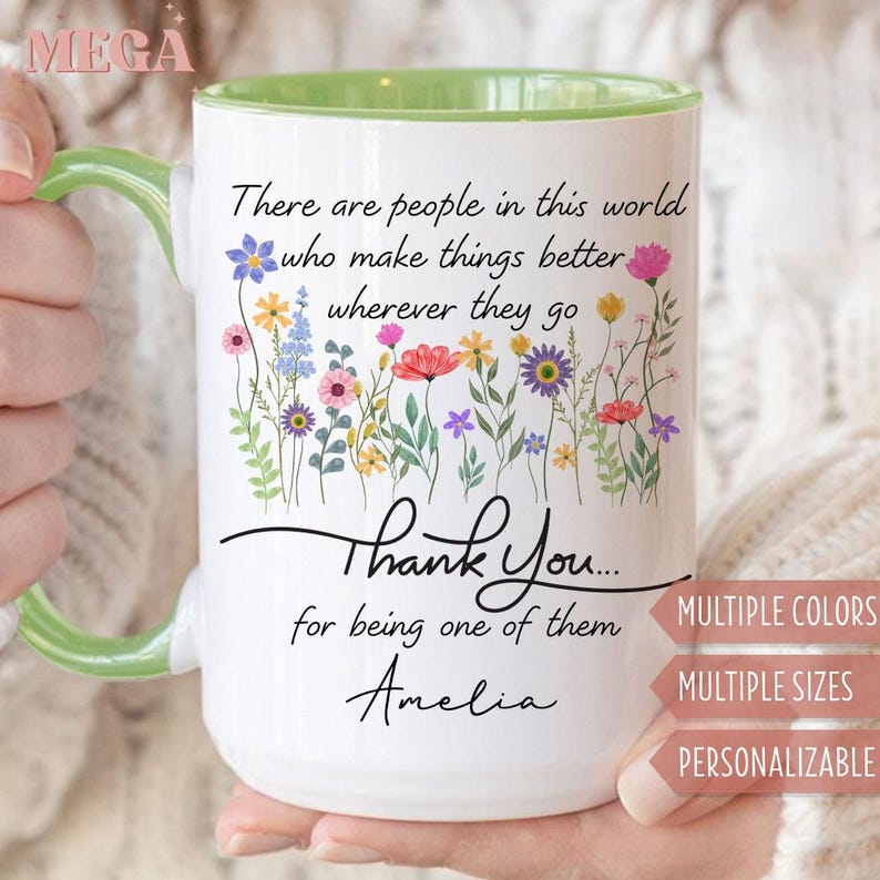 May include: White ceramic mug with a green handle and interior rim. The mug features a floral design and the text "There are people in this world who make things better wherever they go. Thank You... for being one of them Amelia."