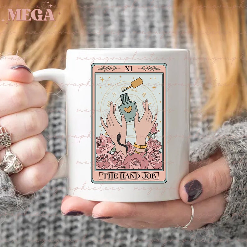 May include: White ceramic mug with a pink and blue illustration of a tarot card. The card is labeled "XI" and "THE HAND JOB".