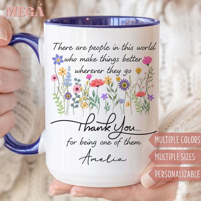 May include: White ceramic mug with a blue handle and rim, featuring a floral design and the text "There are people in this world who make things better wherever they go. Thank You... for being one of them Amelia."