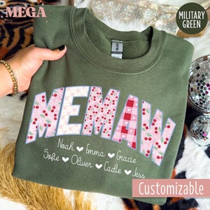 Könnte beinhalten: Olivgrünes Sweatshirt mit dem Wort "MEMAW" in einer dekorativen Schriftart. Die Buchstaben sind mit Kirsch- und Vichy-Mustern gefüllt. Darunter stehen Namen mit Herzen. Der Text "Customizable" steht unten.