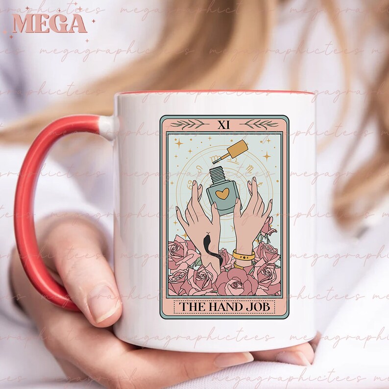 May include: White ceramic mug with a red handle. The mug features a tarot card design with a light blue background and pink roses. The card depicts two hands holding a bottle of nail polish. The card is labeled "XI" and "THE HAND JOB".
