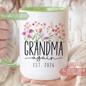 May include: A white ceramic mug with a black handle and the text "But First, Coffee" in a bold, black font. The mug is filled with a dark liquid, likely coffee, and sits on a light-colored surface.