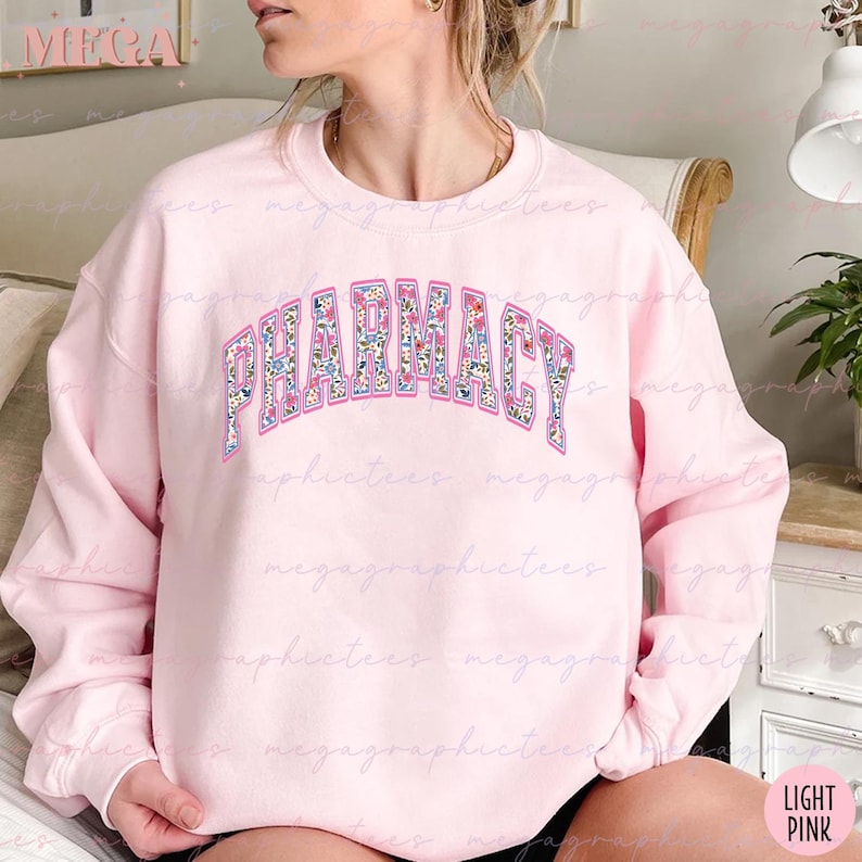 Pu&ograve; includere: Una felpa rosa chiaro con la parola "PHARMACY" stampata in un motivo floreale sul davanti. La felpa &egrave; a collo rotondo e ha maniche lunghe.