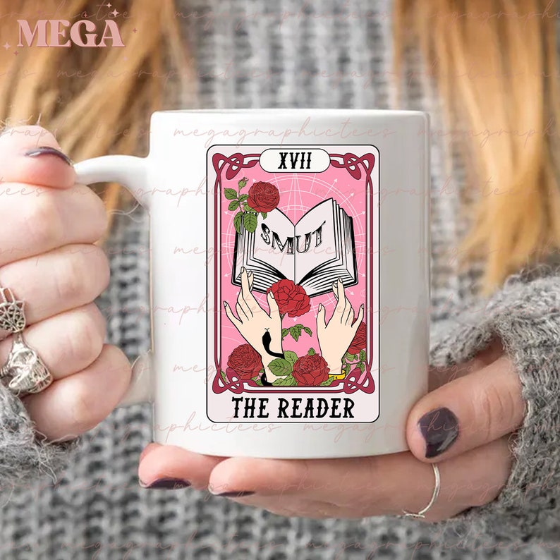 May include: White ceramic mug with a pink and white tarot card design. The card is labeled "XVIII The Reader" and features a book with the word "SMUT" on the cover.