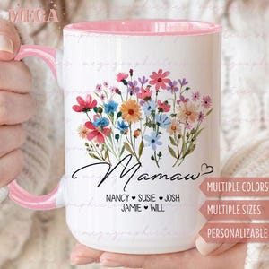 May include: White ceramic mug with a pink rim and handle. The mug features a floral design with the word "Mamaw" and the names "Nancy, Susie, Josh, Jamie, Will" written below. The mug also has the text "Multiple Colors, Multiple Sizes, Personalizable".