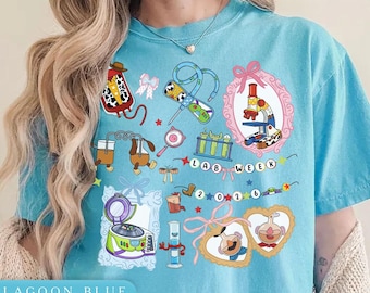 May include: Lagoon blue t-shirt with a colorful graphic design. The design includes lab-themed illustrations such as a microscope, test tubes, and a centrifuge. The text "LAB WEEK 2026" is also featured.