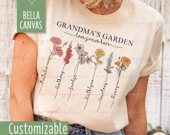 May include: A beige t-shirt with the text "Grandma's Garden, love grows here" and a floral design with names written below each flower. The text "Customizable" is at the bottom of the shirt.