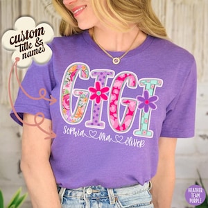 Może przedstawiać: Fioletowa koszulka z napisem "GIGI" w dużych, ozdobnych literach. Litery wypełnione są wzorami kwiatowymi, kropkami i sercami. Pod słowem znajdują się imiona "Sophia", "Mia" i "Oliver". Koszulka ma również napis "custom title & names".