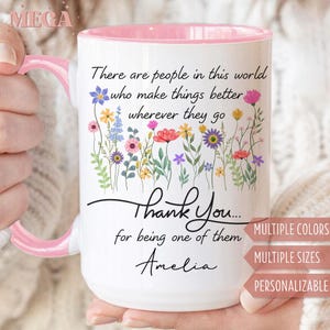 May include: White ceramic mug with a pink interior and handle. The mug features a floral design and the text "There are people in this world who make things better wherever they go. Thank You... for being one of them Amelia."